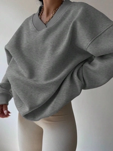 Close-up of gray V-neck sweatshirt featuring ribbed cuffs and drop shoulder detail