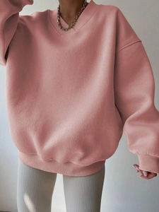 Detail of pink oversize sweatshirt featuring a ribbed V-neckline and casual drop shoulders