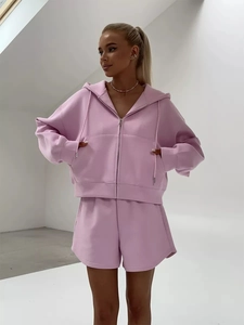 Detail of pink lounge set featuring hooded zip-up sweatshirt and high-waist shorts