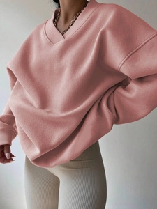 Detail of pink oversized sweatshirt showing ribbed crew neck and soft knit texture