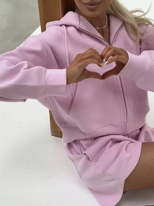 Detailed view of pink hooded zip-up sweatshirt and matching shorts on a model