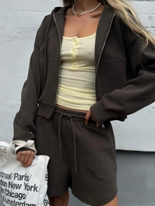 Detail of a brown zip-up hoodie set with yellow ribbed vest and drawstring shorts