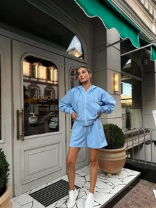 Detail of light blue two-piece lounge set with zip-up hoodie and drawstring shorts
