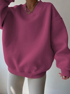Detail of dark purple oversized sweatshirt featuring ribbed cuffs and a deep V-neckline