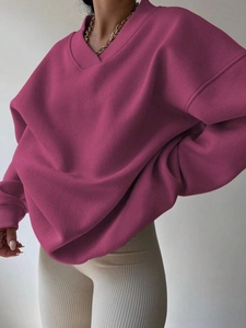 Close-up of ribbed cuffs and V-neckline on oversized magenta long sleeve sweatshirt