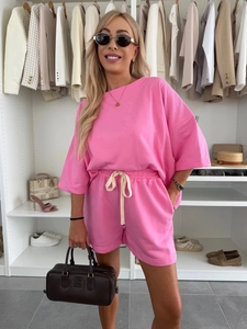 Detail of pink lounge set featuring drop-shoulder t-shirt and drawstring shorts