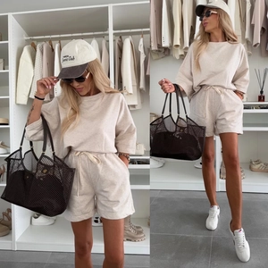 Detail of beige knit lounge set featuring crewneck sweatshirt and drawstring shorts