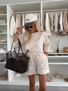 Detail of beige two-piece lounge set with drawstring shorts and oversized t-shirt