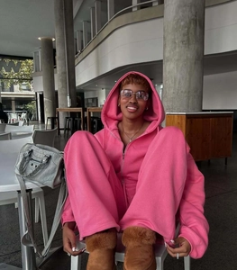 Detail of pink oversized hoodie and matching wide-leg sweatpants set with platform boots