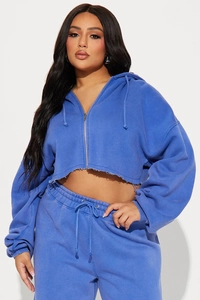 Close-up of royal blue cropped zip-up hoodie with drawstring and raw cut hem detail