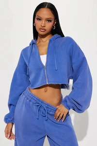 Detail of blue cropped hoodie set showing raw hem edge and matching drawstring waist