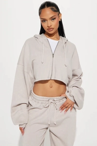 Detail of oatmeal cropped zip-up hoodie and matching joggers with soft fabric texture