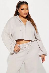 Detail of grey cropped zip-up hoodie and high-waisted joggers with drawstring