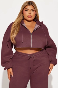 Detail of cropped zip-up hoodie and high-waisted joggers in deep burgundy sweatshirt fabric