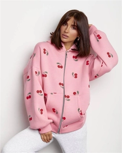 Detail of pink oversized hoodie showing cherry prints, front pockets and zipper closure