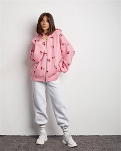 Detail of pink hoodie with cherry print featuring a zip closure and soft cotton fabric