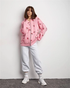 Detailed view of pink zip-up hoodie with red cherry prints and grey joggers set