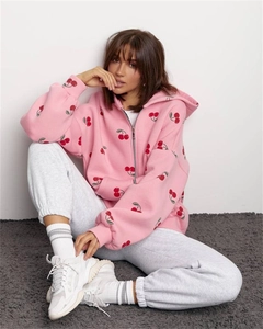 Close-up of pink zip-up hoodie featuring vibrant red cherry prints on soft thick cotton