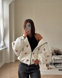 Detailed view of oversized white zip-up hoodie with red cherry print and drop shoulders