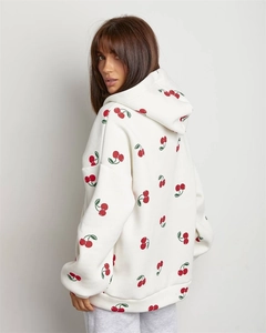 Detail view of the cherry print pattern on white oversized hoodie with ribbed cuffs