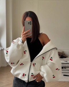 Detailed view of white oversized hoodie featuring a red cherry print and zipper closure