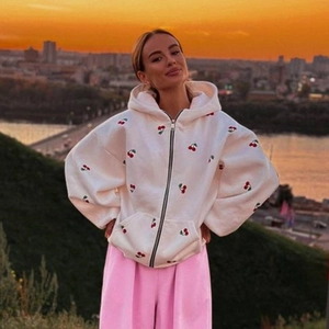 Loose white zip-up hoodie with cherry print and pink wide-leg pants for outdoor city street style