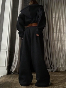 Rear view of heavy cotton knit tracksuit showing cropped hoodie and wide leg pants in black