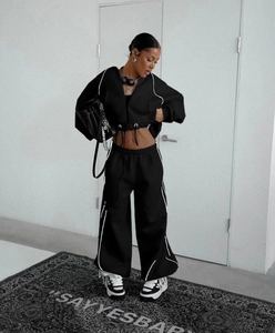 Detail of black tracksuit with white reflective piping and cropped zip hoodie design