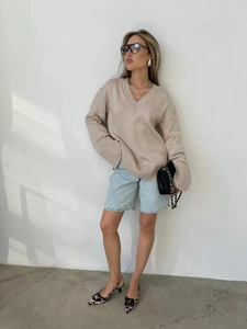Dettaglio del maglione in maglia oversize con scollo a V e colletto a coste e texture