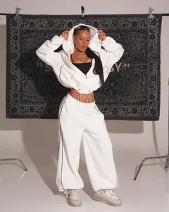 Detailed view of white hooded tracksuit featuring black contrast stitching and drawstrings