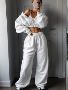 Detail view of white drawstring elastic waistband on high-waist wide-leg sweatpants