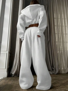 Detail of white hooded sweatshirt and high-waisted wide-leg joggers in thick soft cotton