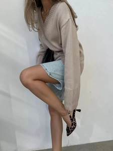 Stile autunnale chic con maglione in maglia beige con scollo a V e gonna in denim