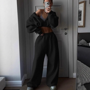 Women's black two-piece sporty set featuring cropped zip hoodie and wide-leg sweatpants