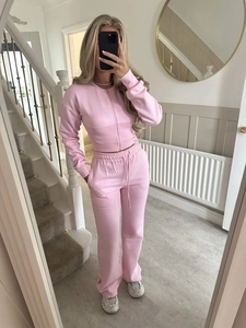 Detail of pink lounge set featuring a slim fit zip-up jacket and wide leg drawstring pants