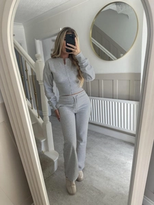 Detail of light grey ribbed knit lounge set featuring zip-up cardigan and drawstring pants