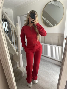 Detail view of red two-piece tracksuit with zip-up jacket and drawstring sweatpants
