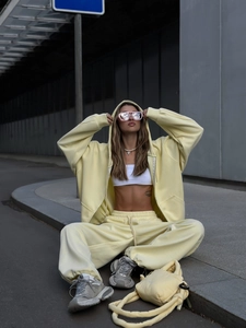 Detalle de conjunto amarillo de dos piezas con sudadera y bolso a juego estilo urbano