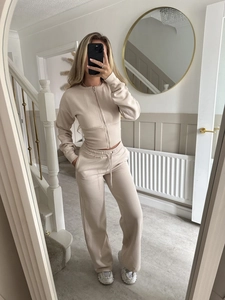 Detailed texture of beige two-piece lounge set featuring a slim zip-up top and wide-leg pants