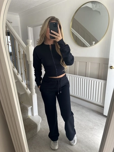 Detailed mirror view of black ribbed knit two-piece zip-up tracksuit set