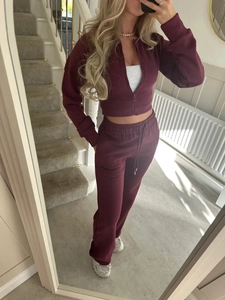Detail of burgundy lounge set featuring zip-up cropped jacket and high waist drawstring pants