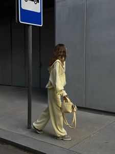 Detalle del chándal amarillo pálido con sudadera con capucha y bolso bandolera acolchado