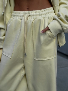 Detalle de pantalón de chándal crema con cintura con cordón y grandes bolsillos de parche