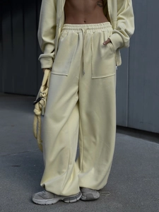 Detalle del conjunto urbano amarillo claro mostrando pantalones anchos y la sudadera