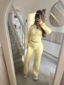 Detailed texture of light yellow ribbed knit tracksuit with zipper and high waist pants