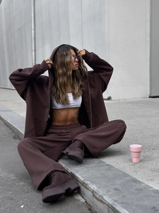 Detalle de la sudadera con capucha marrón oscuro y los pantalones anchos estilo urbano