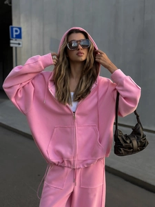 Detalle de un chándal rosa de estilo urbano con sudadera con capucha y pantalón ancho