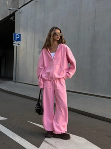 Vista detallada del conjunto rosa de sudadera con capucha y cremallera con pantalón ancho