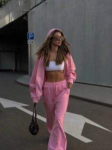 Detalle de sudadera rosa con cremallera y pantalones anchos de talle alto en algodón