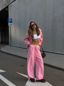Detalle de conjunto rosa con sudadera con capucha y cremallera y pantalón ancho